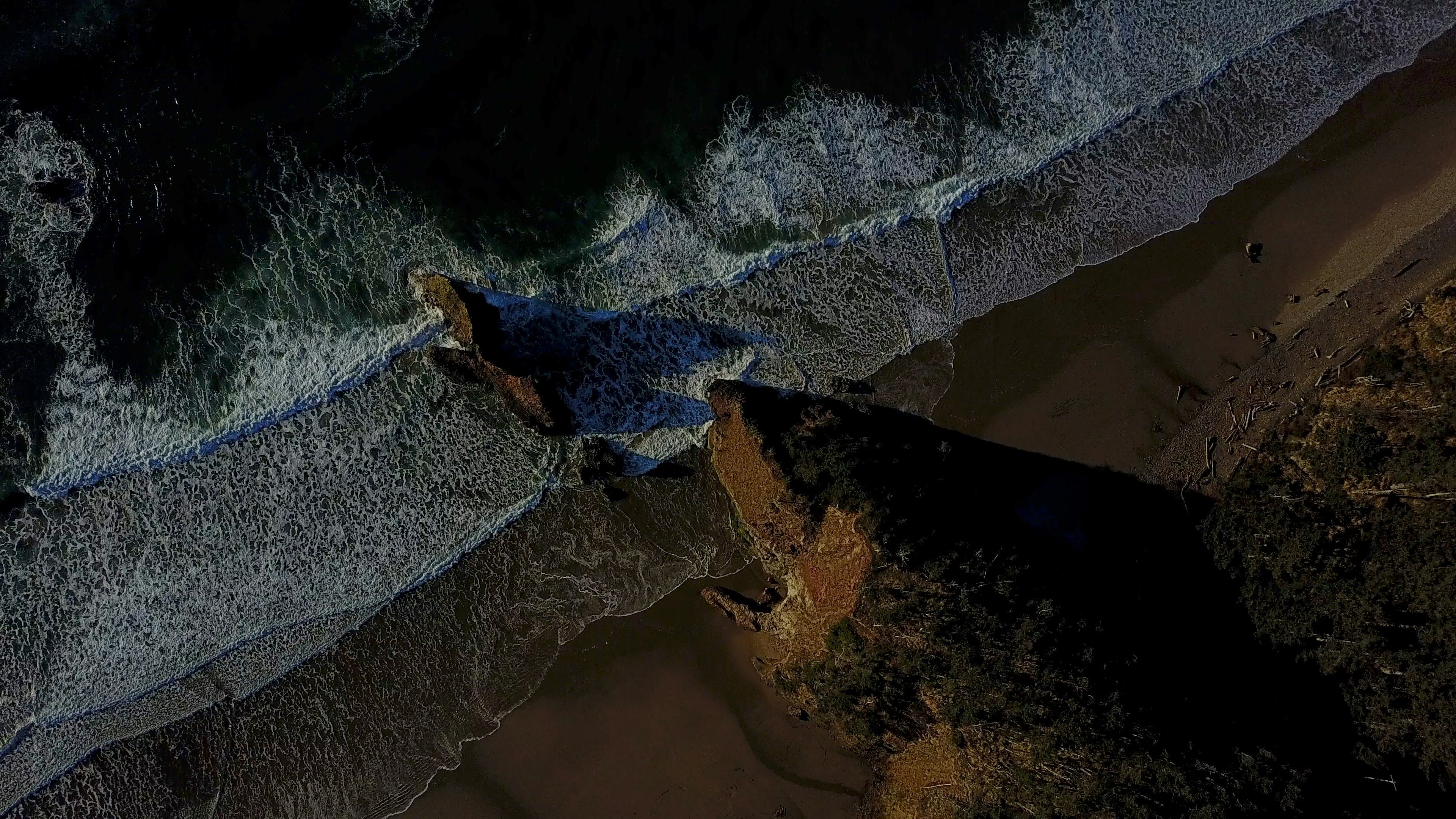 aerial photography of water waves and rock formation during daytime